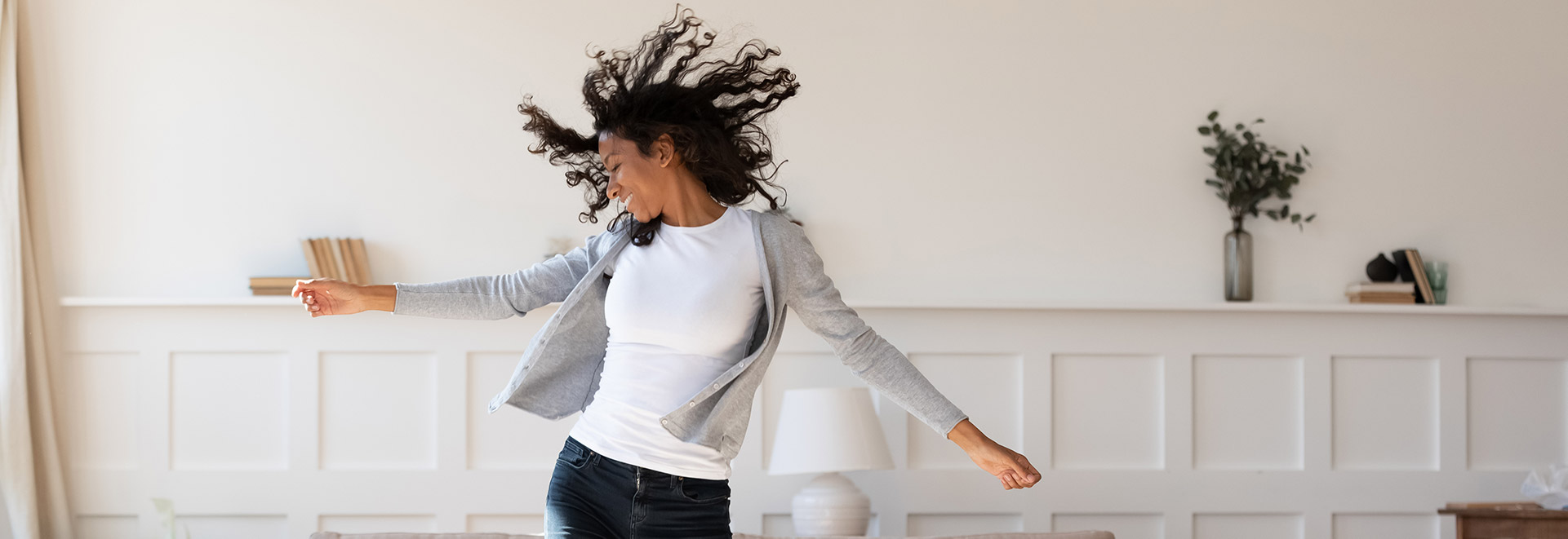 Woman joyfully dancing on a sprung floor in a well-lit, elegant room.