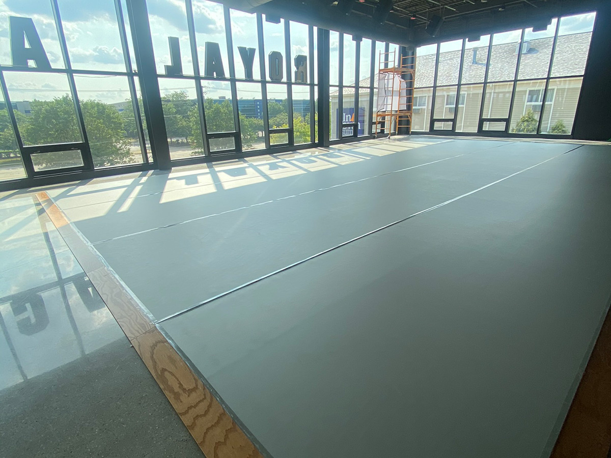 High-quality professional sprung dance floor installed in a studio with large windows and natural light, providing optimal surface for dance and performance activities.