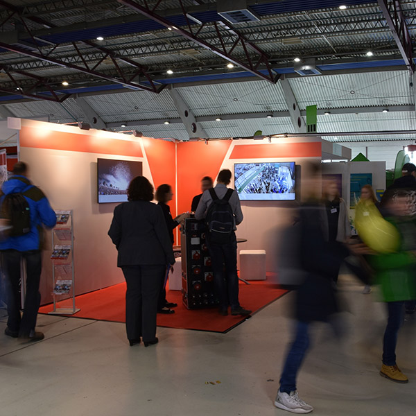 Sprung Floors trade show booth with attendees and informational displays.