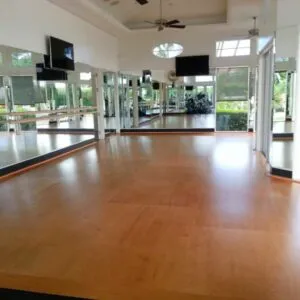 Golden Maple fitness floor in brightly lit exercise studio with large mirrors.