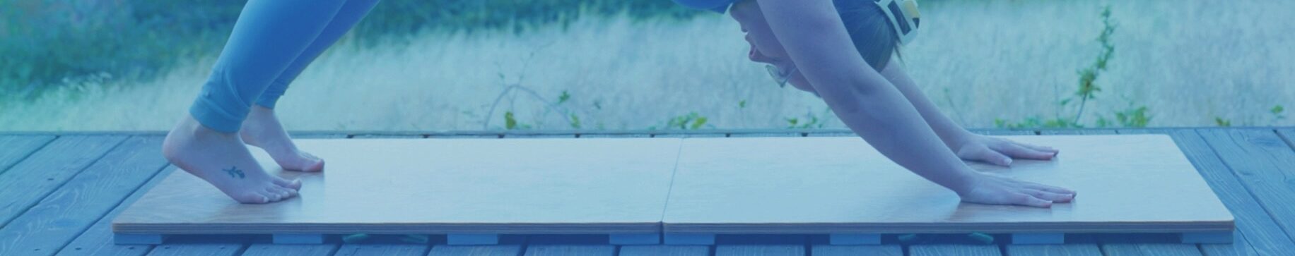 Person performing yoga on a Sprung Floors precision practice dance and exercise floor outdoor on a deck at dusk.